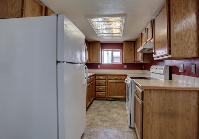 3222 W 4th Ave, Spokane, WA 99224 - kitchen featuring white appliances, under cabinet range hood, brown cabinetry, and light countertops
