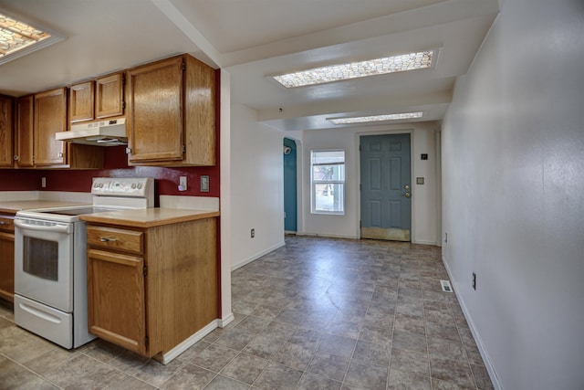 3222 W 4th Ave, Spokane, WA 99224 - kitchen with white range with electric cooktop, under cabinet range hood, light countertops, and brown cabinets