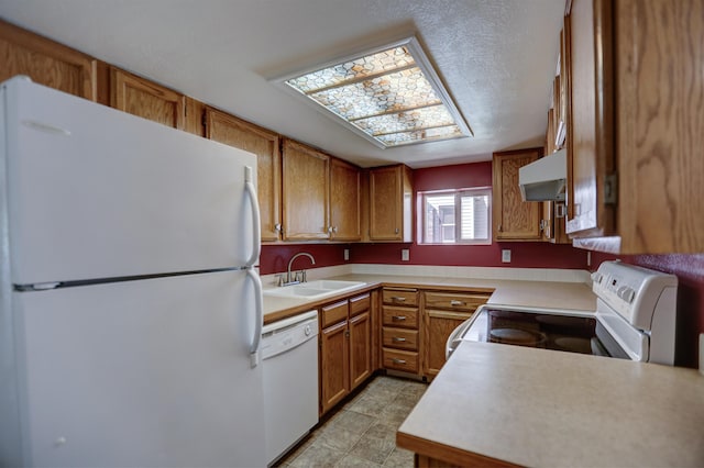 3222 W 4th Ave, Spokane, WA 99224 - kitchen featuring white appliances, under cabinet range hood, light countertops, and brown cabinets