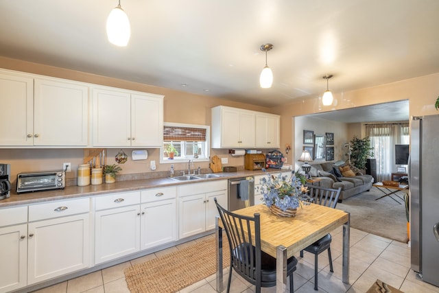 814 E Montgomery Ave, Spokane, WA 99207 - kitchen with open floor plan, stainless steel appliances, white cabinetry, and light tile patterned floors