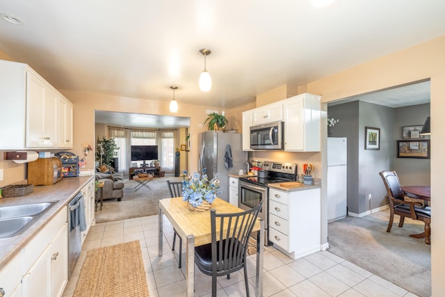 814 E Montgomery Ave, Spokane, WA 99207 - kitchen featuring stainless steel appliances, light colored carpet, light tile patterned floors, open floor plan, and white cabinets