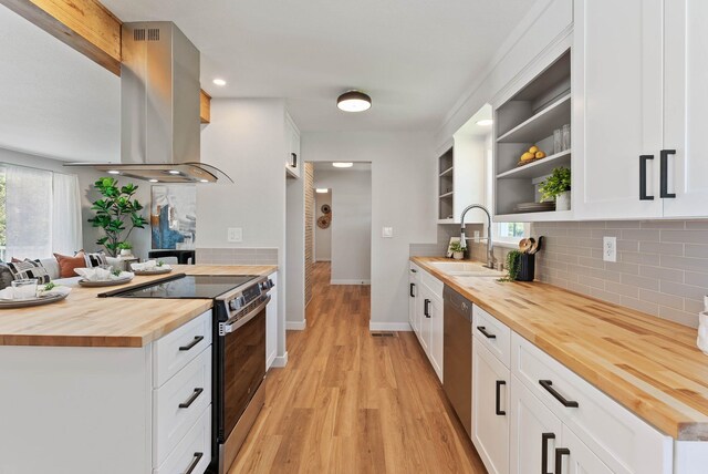 4017 E Pratt Ave, Spokane, WA 99204 - kitchen with wood counters, appliances with stainless steel finishes, open shelves, island range hood, and light wood finished floors