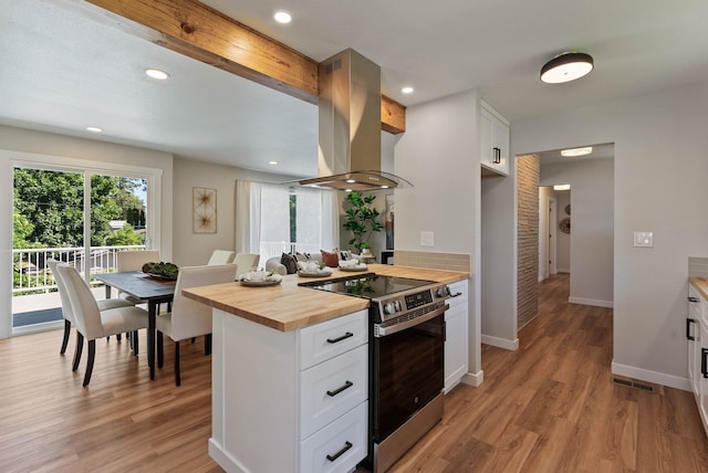 4017 E Pratt Ave, Spokane, WA 99204 - kitchen featuring butcher block counters, island exhaust hood, stainless steel electric stove, light wood-style floors, and white cabinetry