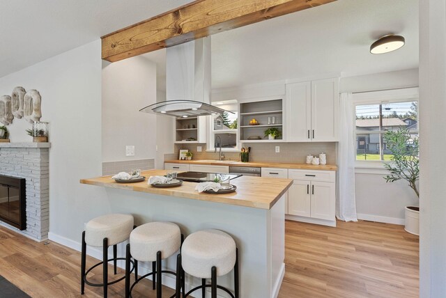 4017 E Pratt Ave, Spokane, WA 99204 - kitchen with wooden counters, open shelves, a kitchen breakfast bar, island exhaust hood, and white cabinetry
