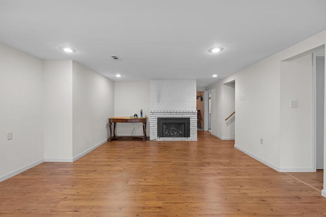 4335 W Excell Ave, Spokane, WA 99208 - unfurnished living room with light wood finished floors, a large fireplace, recessed lighting, and stairway