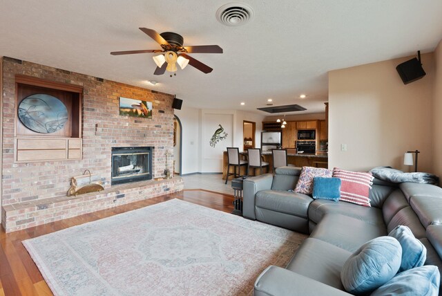 3314 W Eagles Nest Ln, Spokane, WA 99208 - living room with light wood-style flooring, a ceiling fan, recessed lighting, and a fireplace