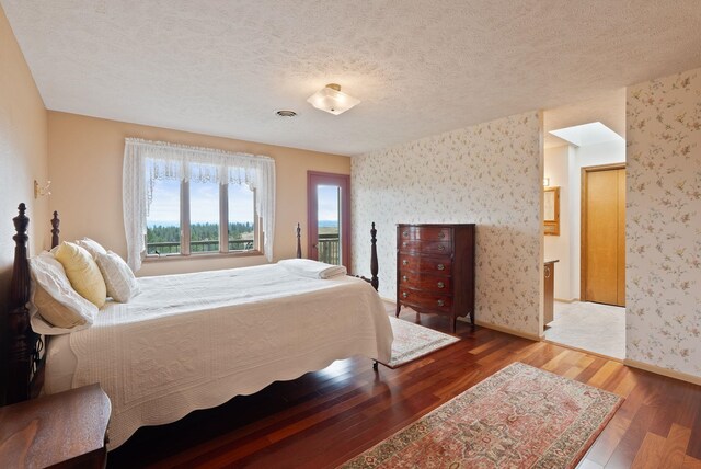 3314 W Eagles Nest Ln, Spokane, WA 99208 - bedroom featuring wallpapered walls, wood finished floors, and a textured ceiling