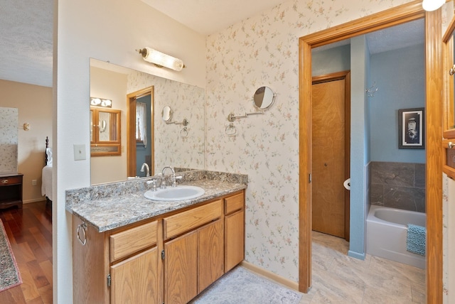 3314 W Eagles Nest Ln, Spokane, WA 99208 - ensuite bathroom with a garden tub, vanity, wood finished floors, and wallpapered walls