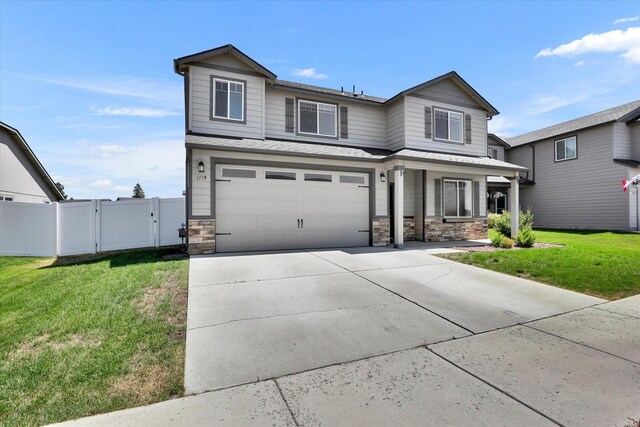 1119 S Soda Rd, Spokane, WA 99224 - traditional home with stone siding, a gate, an attached garage, concrete driveway, and covered porch