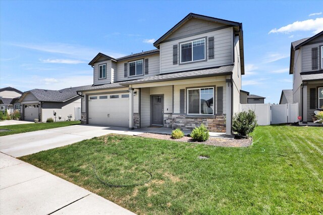 1119 S Soda Rd, Spokane, WA 99224 - view of front of property with concrete driveway, stone siding, a garage, roof with shingles, and covered porch