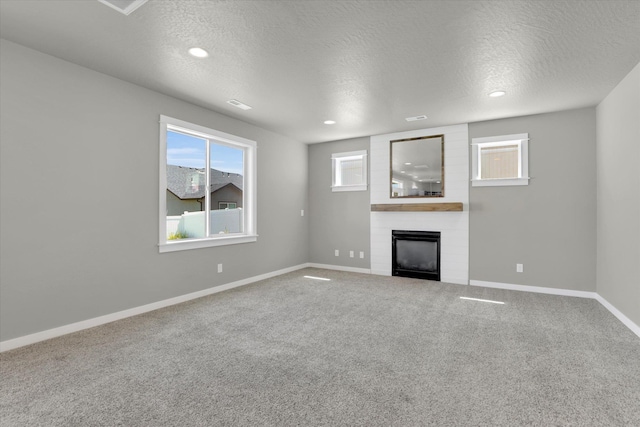 1119 S Soda Rd, Spokane, WA 99224 - unfurnished living room featuring a fireplace, a textured ceiling, and carpet