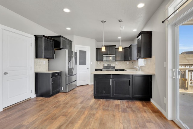 1119 S Soda Rd, Spokane, WA 99224 - kitchen featuring stainless steel appliances, light countertops, backsplash, light wood-style floors, and recessed lighting
