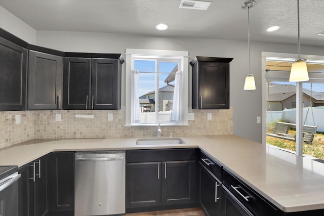 1119 S Soda Rd, Spokane, WA 99224 - kitchen featuring dishwasher, backsplash, light countertops, a peninsula, and recessed lighting