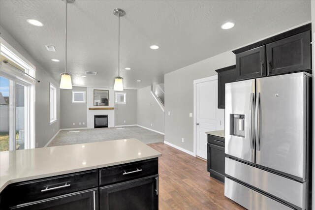 1119 S Soda Rd, Spokane, WA 99224 - kitchen featuring stainless steel fridge, dark cabinetry, light countertops, hanging light fixtures, and recessed lighting