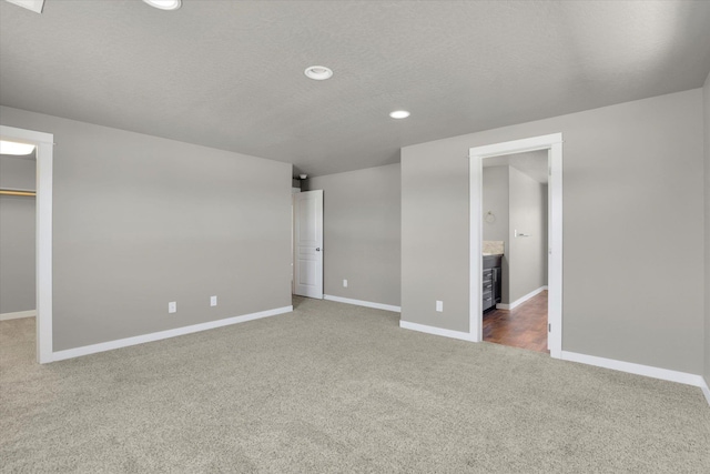 1119 S Soda Rd, Spokane, WA 99224 - unfurnished bedroom with carpet flooring, a spacious closet, recessed lighting, ensuite bath, and a textured ceiling