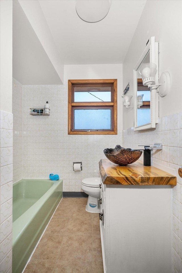7616 E Baldwin Ave, Spokane, WA 99212 - full bathroom with tile walls, vanity, a bathtub, tile patterned flooring, and wainscoting
