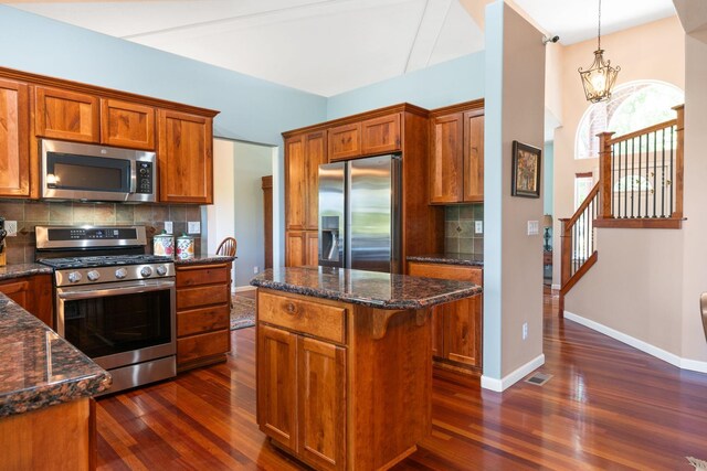 9617 N Northview Ln, Spokane, WA 99208 - kitchen with stainless steel appliances, brown cabinets, dark wood-style floors, and tasteful backsplash