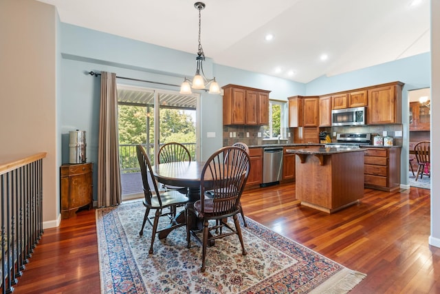 9617 N Northview Ln, Spokane, WA 99208 - kitchen with stainless steel appliances, tasteful backsplash, a kitchen island, brown cabinets, and vaulted ceiling