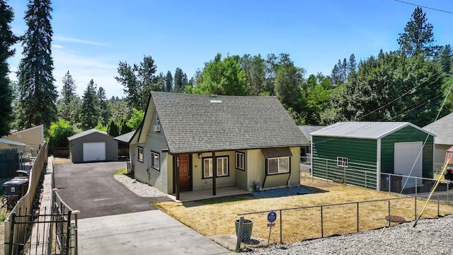 1937 W 15th Ave, Spokane, WA 99224 - view of front of house featuring a detached garage, an outbuilding, a shingled roof, and covered porch