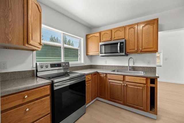 1937 W 15th Ave, Spokane, WA 99224 - kitchen with stainless steel appliances, light wood-style flooring, brown cabinets, and dark countertops