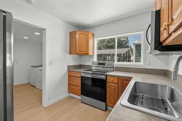1937 W 15th Ave, Spokane, WA 99224 - kitchen featuring stainless steel appliances, washer and clothes dryer, and light wood finished floors