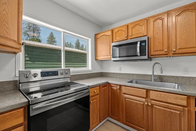 1937 W 15th Ave, Spokane, WA 99224 - kitchen with appliances with stainless steel finishes and brown cabinetry