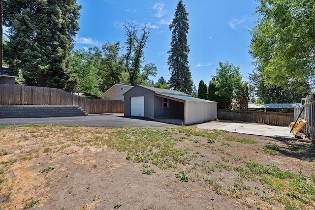 1937 W 15th Ave, Spokane, WA 99224 - fenced backyard featuring an outdoor structure, a patio, a detached garage, and asphalt driveway