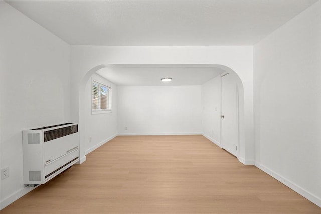 1937 W 15th Ave, Spokane, WA 99224 - unfurnished living room with heating unit, arched walkways, and light wood-style flooring