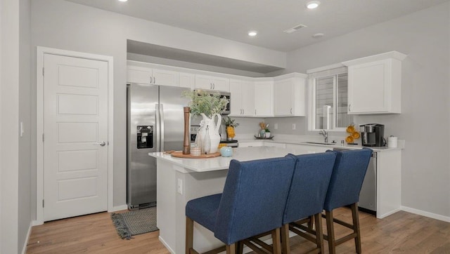 3745 S Keller Ln, Spokane Valley, WA 99206 - kitchen with white cabinets, light wood-style floors, light countertops, a center island, and recessed lighting