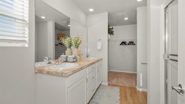 3745 S Keller Ln, Spokane Valley, WA 99206 - bathroom with double vanity, wood finished floors, a spacious closet, and recessed lighting