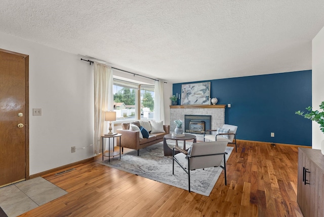 201 W Barnes Rd, Spokane, WA 99218 - living room featuring hardwood / wood-style floors, a glass covered fireplace, and a textured ceiling