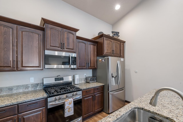 3316 N Coleman St, Post Falls, ID 83854 - kitchen with stainless steel appliances, dark brown cabinetry, light stone counters, and recessed lighting