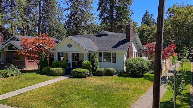 927 W 19th Ave, Spokane, WA 99203 - view of front facade featuring a chimney, covered porch, a front yard, and roof with shingles