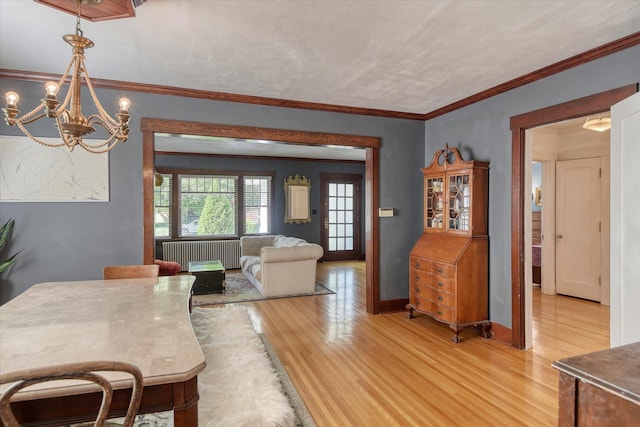 927 W 19th Ave, Spokane, WA 99203 - dining room featuring light wood-style flooring, radiator heating unit, a chandelier, and crown molding