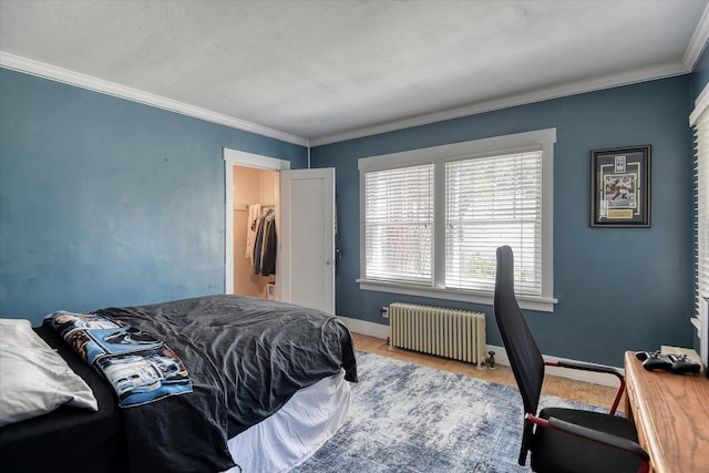 927 W 19th Ave, Spokane, WA 99203 - bedroom featuring radiator heating unit, wood finished floors, ornamental molding, and a walk in closet