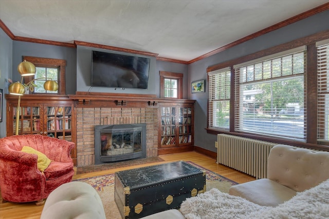 927 W 19th Ave, Spokane, WA 99203 - living room featuring radiator, wood finished floors, ornamental molding, and a brick fireplace