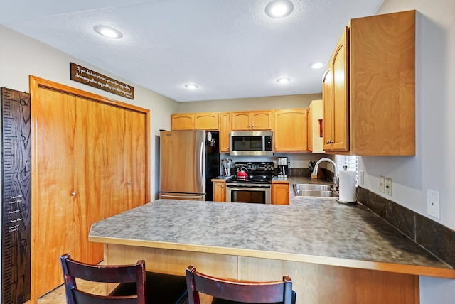 11606 E 8th Ave, Spokane Valley, WA 99206 - kitchen featuring appliances with stainless steel finishes, a peninsula, a kitchen bar, and recessed lighting