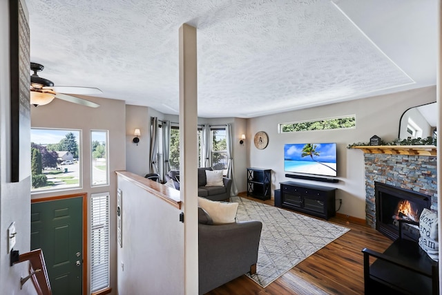 11606 E 8th Ave, Spokane Valley, WA 99206 - living room featuring wood finished floors, a textured ceiling, a ceiling fan, and a fireplace