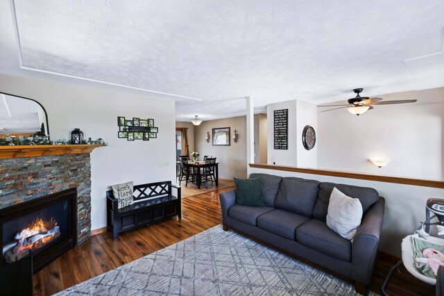11606 E 8th Ave, Spokane Valley, WA 99206 - living area with wood finished floors, ceiling fan, a fireplace, and a textured ceiling