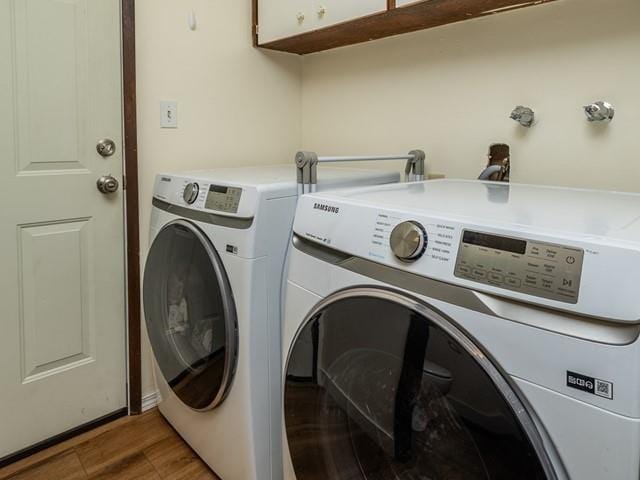 10108 E 19th Ave, Spokane Valley, WA 99206 - washroom featuring separate washer and dryer, light wood-type flooring, and cabinet space