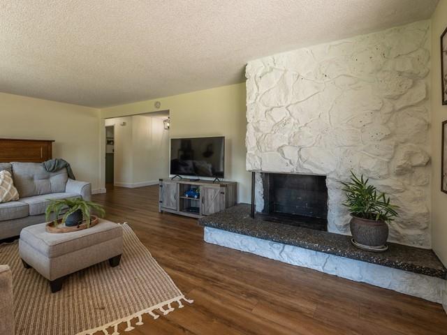 10108 E 19th Ave, Spokane Valley, WA 99206 - living area featuring a textured ceiling, wood finished floors, and a fireplace