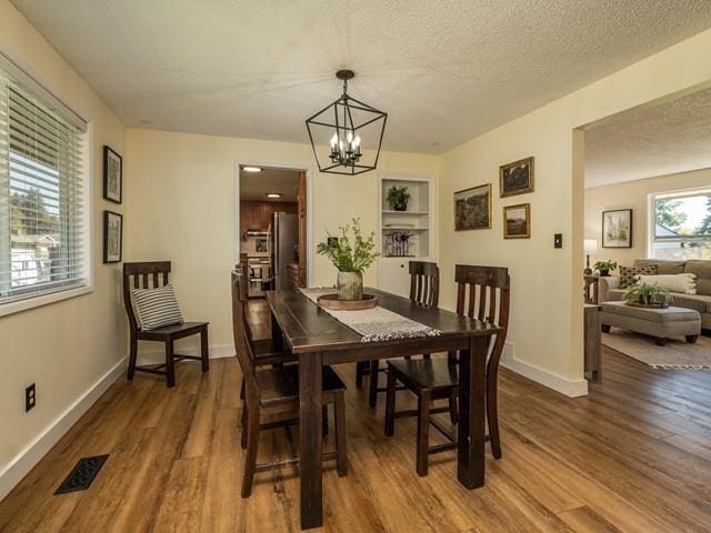 10108 E 19th Ave, Spokane Valley, WA 99206 - dining area with wood finished floors, a chandelier, built in shelves, and a textured ceiling