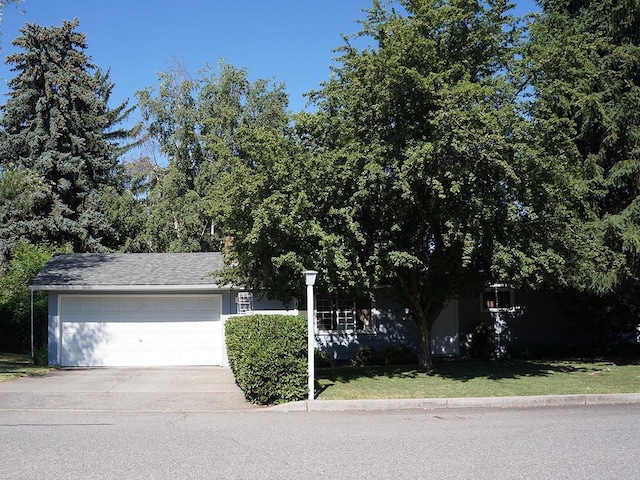 816 S Mamer Rd, Spokane Valley, WA 99216 - obstructed view of property with concrete driveway, an attached garage, and a front lawn