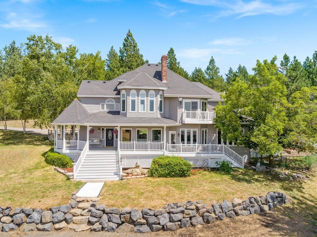 6204 E Custer Ln, Spokane, WA 99223 - back of house featuring a chimney, a lawn, a balcony, a porch, and roof with shingles