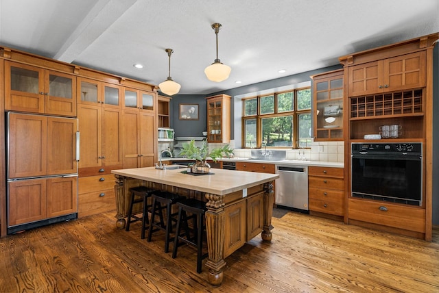 6204 E Custer Ln, Spokane, WA 99223 - kitchen with appliances with stainless steel finishes, light countertops, brown cabinetry, dark wood-style floors, and recessed lighting