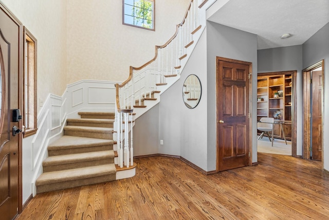 6204 E Custer Ln, Spokane, WA 99223 - foyer entrance featuring light wood-type flooring, stairs, a wainscoted wall, and a decorative wall