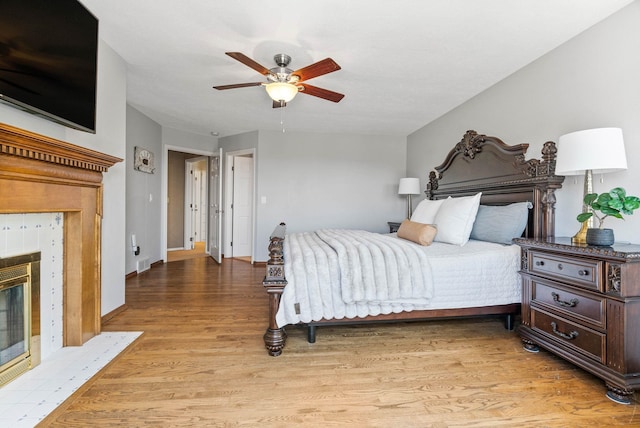 6204 E Custer Ln, Spokane, WA 99223 - bedroom with a fireplace, light wood-type flooring, and a ceiling fan