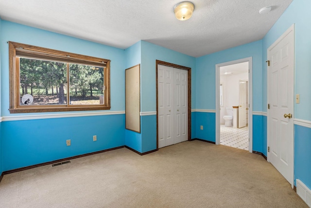 6204 E Custer Ln, Spokane, WA 99223 - unfurnished bedroom with carpet, a textured ceiling, a closet, and ensuite bath