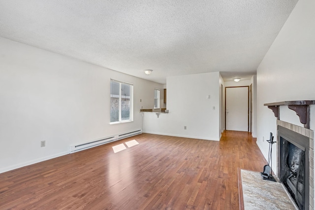 6125 N Addison St, Spokane, WA 99208 - unfurnished living room with a baseboard heating unit, a textured ceiling, a fireplace with flush hearth, and wood finished floors