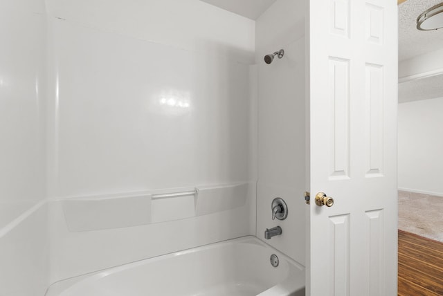 6125 N Addison St, Spokane, WA 99208 - bathroom with bathing tub / shower combination, a textured ceiling, and wood finished floors